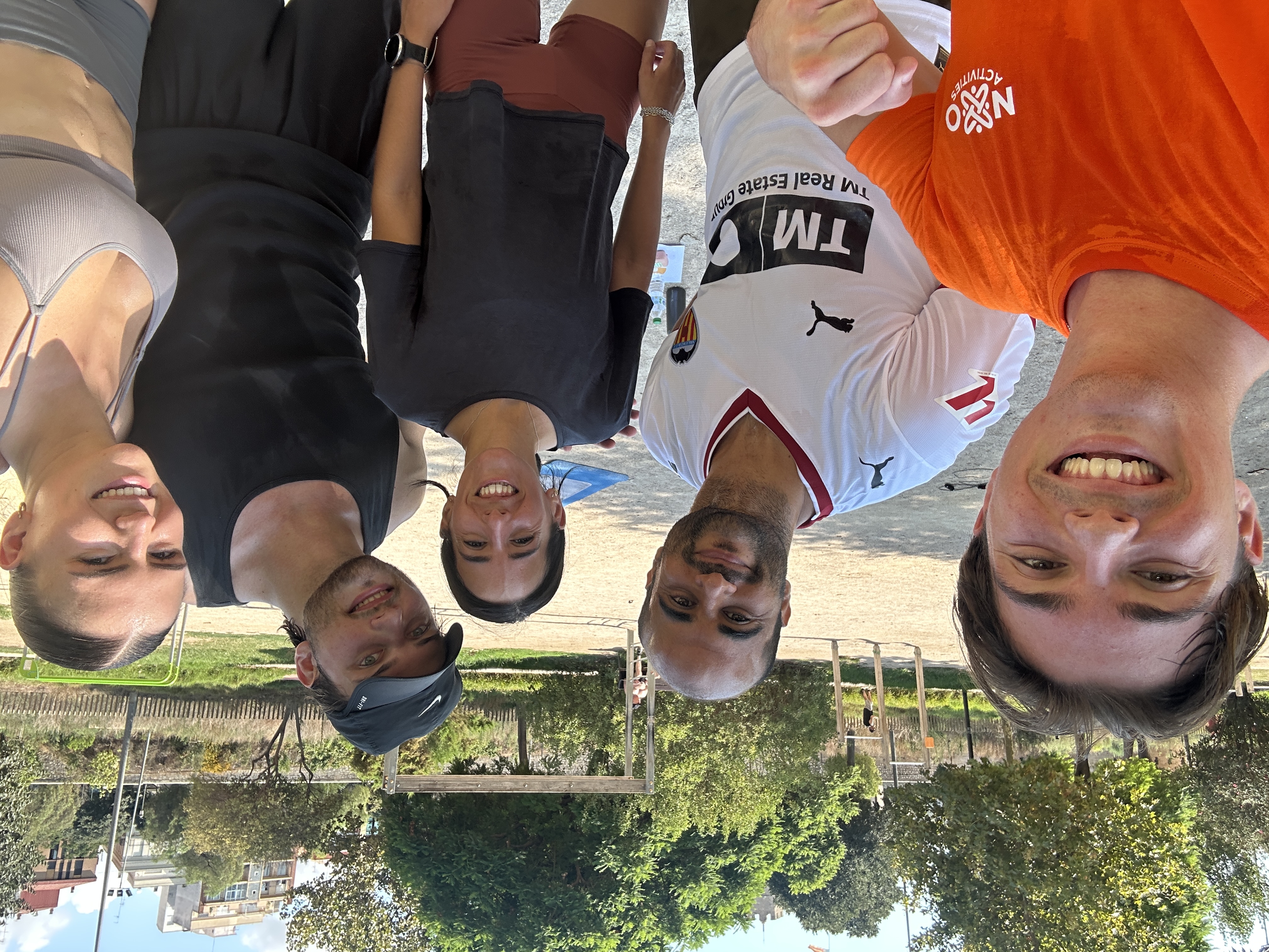 Five members of the Nexo Activities community, including the trainer in an orange Nexo t-shirt, smiling together after Valencia's first Functional Workout + Social Brunch